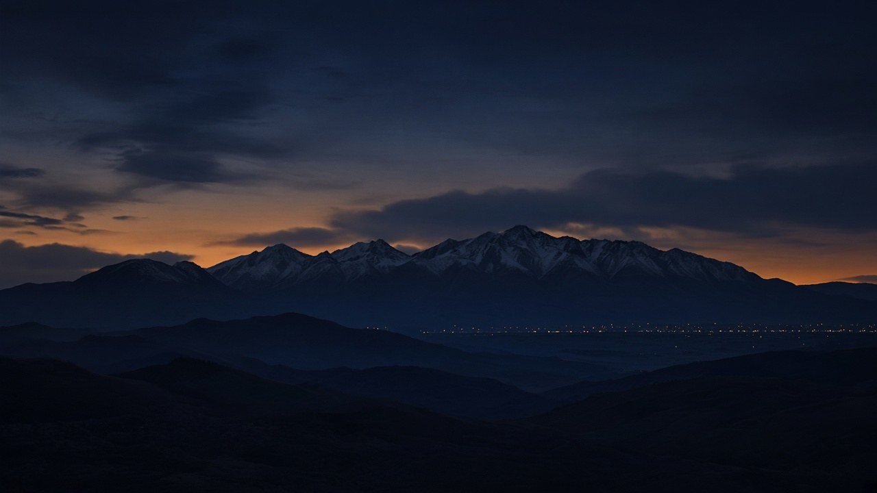 Concept rendering: dark Front Range mountain silhouette at dusk with distant valley lights.